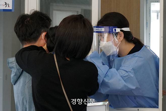 지난 6일 서울역광장 임시선별검사소에서 의료진이 부모의 도움을 받아 한 어린이의 검체를 채취하고 있다. 박민규 선임기자