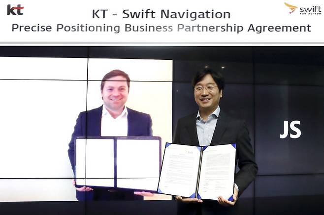 최강림 KT AI 모빌리티사업단장(오른쪽)이 29일 서울 KT송파빌딩에서 티모시 해리스 스위프트 내비게이션 CEO(화면)와 사업계약을 체결한 뒤 기념 촬영을 하고 있다. KT 제공