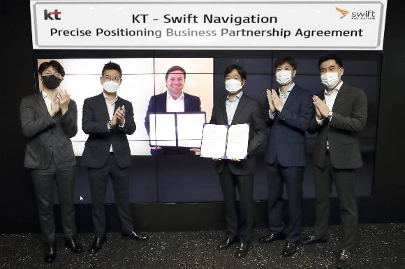 서울 송파구 위치한 KT 송파빌딩에서 KT AI 모빌리티사업단장 최강림 상무가(우측 세번째) 스위프트 내비게이션 CEO 티모시 해리스(화면), KT 유관 임직원들과 함께 기념 촬영을 하고 있다 /사진=KT