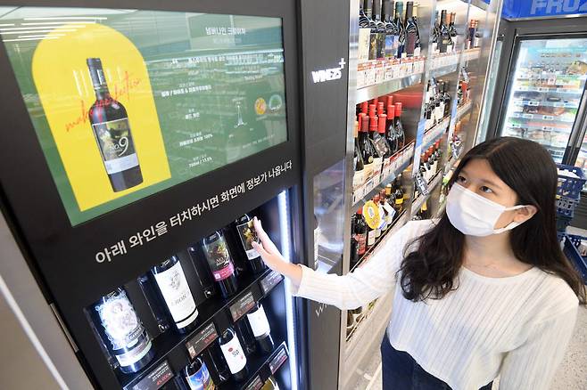 30일 서울 강남구 GS25 DX LAB(디지털 경험 연구소)점에서 고객이 터치를 하면 와인의 정보를 자동으로 알려주는 와인 쇼케이스를 체험하고 있다.