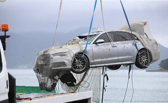 A submerged car which belonged to Cho`s family is being pulled off the shores of Wando, South Jeolla Province, Wednesday. (Yonhap)