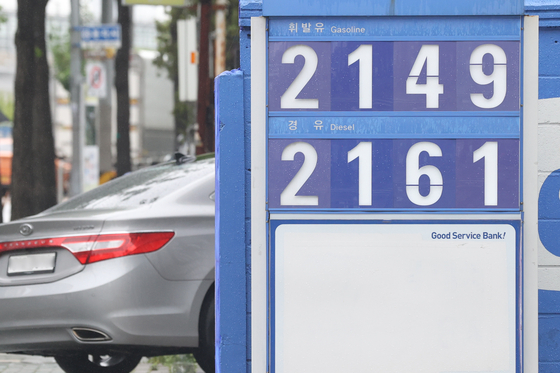 The fuel tax cut will be expanded to 37 percent from the current 30 percent starting July. Additionally, fuel taxes will drop by 57 won ($0.04) per liter for gasoline, by 38 won for diesel and by 12 won for LPG. Gas and diesel prices are displayed at a filling station in Seoul on Thursday. [YONHAP]