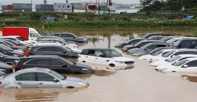 30일 내린 폭우로 경기도 수원시의 한 중고차 단지의 차량들이 물에 잠겨 있다. 연합뉴스