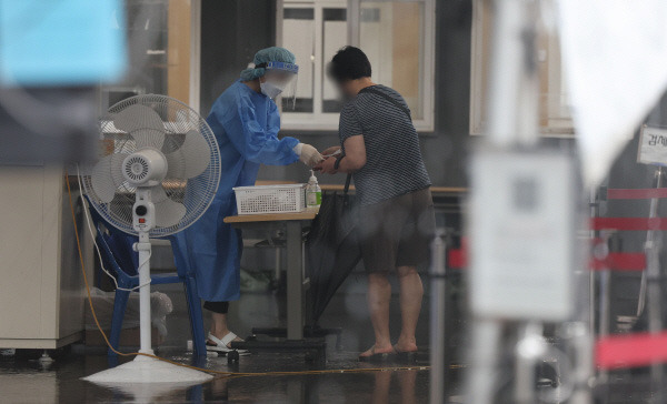 30일 오전 서울역 광장에 마련된 코로나19 임시 선별검사소에서 의료진이 안내를 하고 있다. [사진 = 연합뉴스]