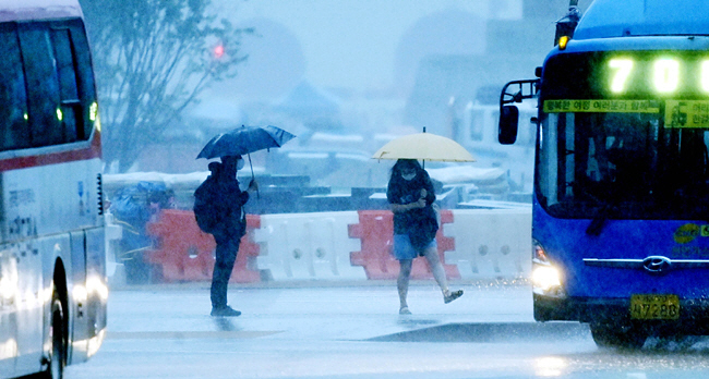 흠뻑 젖은 출근길 :  서울 등 수도권에 호우경보가 내려진 30일 오전 서울 광화문네거리에서 시민들이 우산으로 쏟아지는 비를 막으며 출근하고 있다.    윤성호 기자