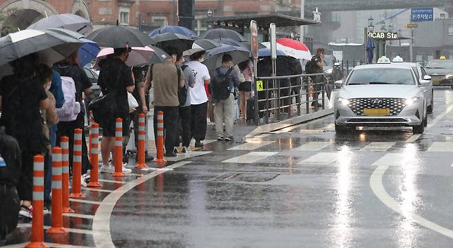 폭우로 서울 시내 도로 곳곳이 침수된 30일 오후 서울역 앞에서 시민들이 택시를 기다리고 있다. 서울시 교통정보시스템에 따르면 이날 오후 3시 기준 서울시 전체 평균 차량 속도는 시속 16.6㎞로 정체가 빚어졌다. [연합]