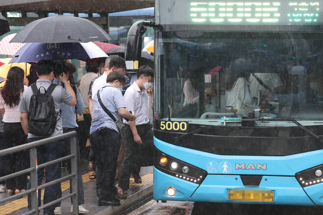 폭우로 서울 시내 도로 곳곳이 침수된 30일 오후 서울역 버스정류장에서 시민들이 버스에 탑승하고 있다. 서울시 교통정보시스템에 따르면 이날 오후 3시 기준 서울시 전체 평균 차량 속도는 시속 16.6㎞로 정체가 빚어졌다. [연합]