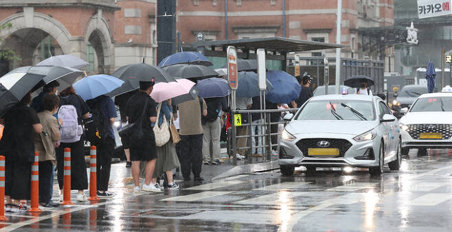 폭우로 서울 시내 도로 곳곳이 침수된 30일 오후 서울역 앞에서 시민들이 택시를 기다리고 있다.   연합뉴스