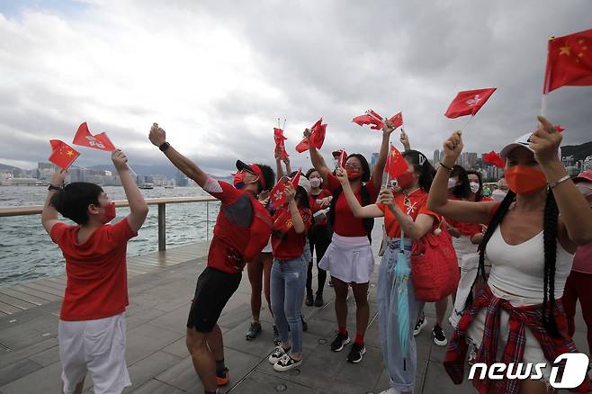시민들이 홍콩특별행정구 구기인 양자형기가와 중국 오성홍기를 흔들고 있다. © 로이터=뉴스1 © News1 정윤영 기자