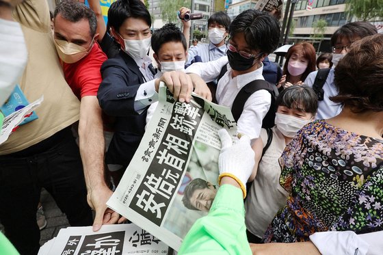 8일 일본 도쿄에서 시민들이 아베 전 총리의 피습 사실을 알리는 호외를 받고 있다. [AFP=연합뉴스]