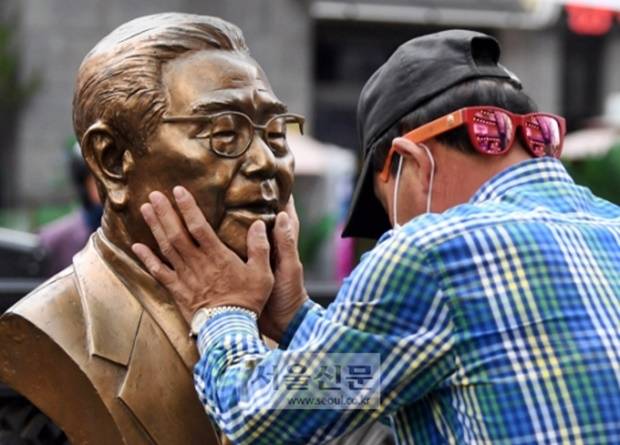 지난 6월 8일 한 시민이 서울 종로구 송해길에 설치된 흉상을 어루만지며 고인을 추모하고 있는 모습.서울신문 박윤슬 기자.