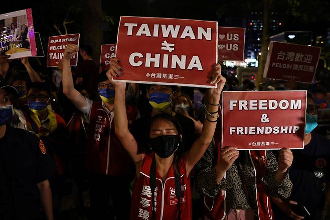 2일(현지 시각) 대만 타이베이에서 낸시 펠로시 미국 하원의장의 방문을 지지하는 시위대가 '대만은 중국이 아니다'(가운데)라고 적힌 피켓을 들고 있다. 미국 권력 서열 3위인 펠로시 의장은 중국의 강력 반발에도 이날 대만을 방문했다. /로이터 연합뉴스