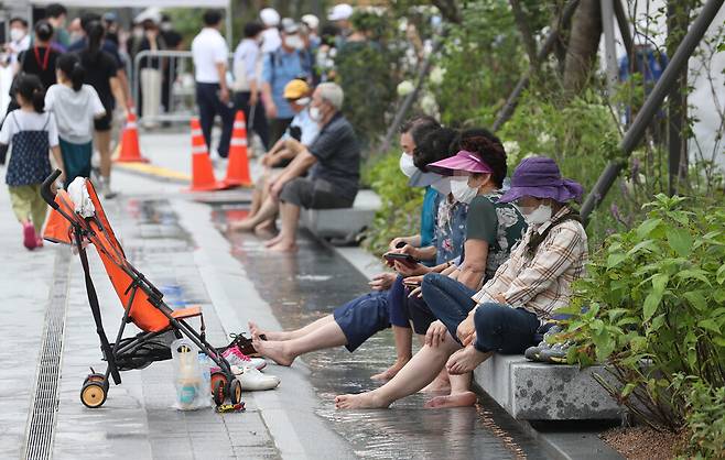 6일 오후 서울 광화문광장을 찾은 시민들이 ‘역사물길’에 발을 담근 채 휴식을 취하고 있다. 강창광 선임기자