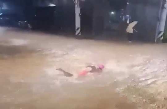 서울 관악구 신림동의 침수된 도로에서 한 남성이 수영을 하는 모습. 사진=온라인 커뮤니티 갈무리
