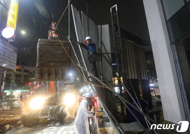 폭우가 내린 8일 오후 서울 중구 약수역 인근 공사현장에 가림판이 쓰러져 관계자들이 정리작업을 하고 있다. 2022.8.8/뉴스1 ⓒ News1 송원영 기자