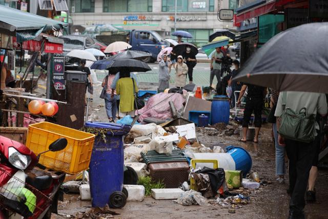 9일 폭우로 침수피해를 입은 서울 동작구 남성사계시장의 상인들이 상점을 복구하고 있다. 연합뉴스