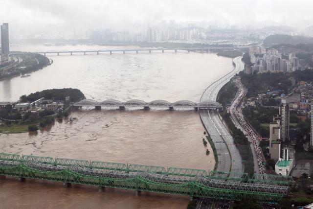 서울을 포함한 수도권에 집중된 폭우로 인해 한강 수위가 급격히 상승한 9일 오전 흙탕물로 변한 한강 옆으로 올림픽대로가 통제되어 있다. 연합뉴스