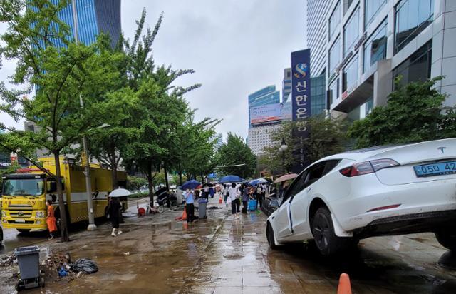 9일 오전 서울 강남역 진흥아파트 인근 건물에서 전날 내린 폭우로 인해 주차된 차량이 설치된 화단을 올라타 출입구를 막아선 채 방치되어 있다. 김재현 기자
