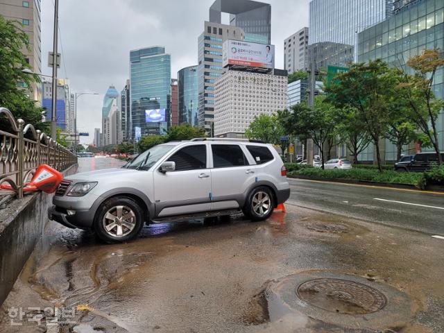 9일 오후 교대역 방면 진흥아파트 부근 도로 앞에 전날 폭우로 침수된 차량이 여전히 방치돼 있다. 김재현 기자