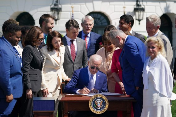 조 바이든(가운데) 미국 대통령이 9일(현지시간) 워싱턴 백악관 외곽의 사우스론에서 카멀라 해리스(왼쪽 2번째) 부통령 등이 지켜보는 가운데 '2022 반도체와 과학법'에 서명하고 있다. AFP연합