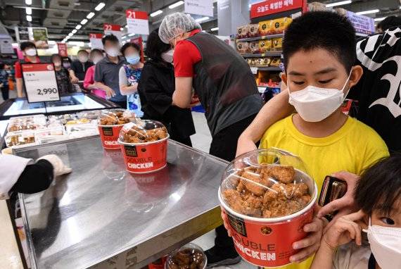 지난 8일 서울 홈플러스 영등포점에서 한 가족이 40팩 한정으로 판매되는 두 마리 후라이드 치킨 할인 상품을 구매하고 있다. 홈플러스 서울 영등포점은 이날 기존 1만5990원의 제품을 9990원에 한정 판매했다. 판매 시작 약 3분 만에 소진됐다. /뉴스1