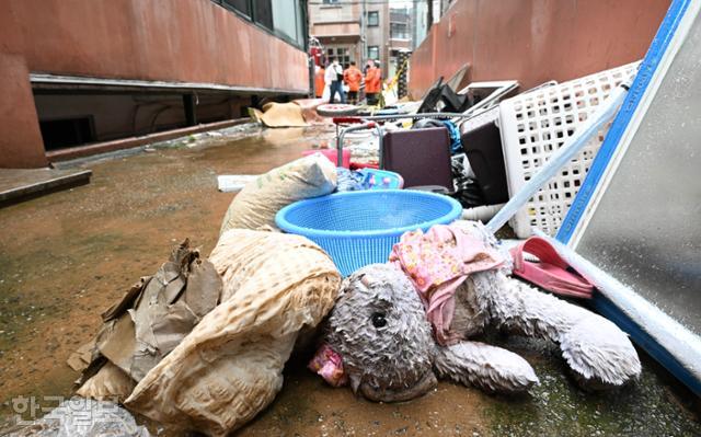 8일 폭우로 침수돼 일가족 3명이 갇혀 숨진 서울 관악구 신사동의 한 빌라 입구에 이튿날 아이들 인형과 옷가지 등이 널부러져 있다. 배우한 기자