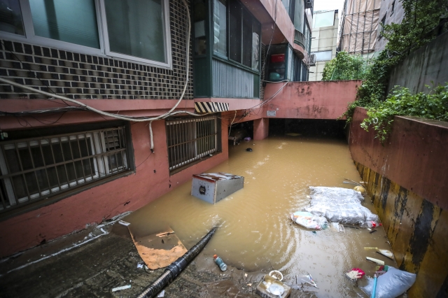 지난 8일 폭우로 서울 관악구의 한 빌라 반지하가 침수돼 일가족 3명이 갇혀 사망하는 일이 발생했다. 사진은 9일 오후   해당 빌라 주차장에 물이 차있는 모습. 뉴시스