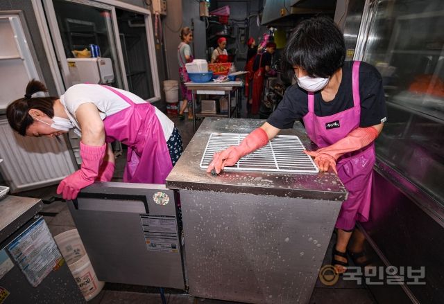 10일 서울 동작구 남성사계시장에서 반찬가게 종업원들이 냉장고를 씻고 있다.