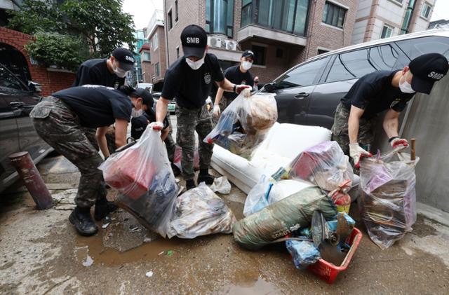 10일 오후 서울 관악구 신사동 일대에서 수도방위사령부 장병들이 침수 가구에서 집기류 수해폐기물을 처리하고 있다. 연합뉴스
