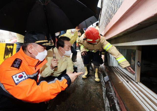 윤석열 대통령이 9일 서울 관악구 신림동 호우 피해 현장을 방문하고 있다. 이 현장은 폭우에 따른 침수로 일가족 3명이 목숨을 잃은 반지하 주택이었다. 연합뉴스
