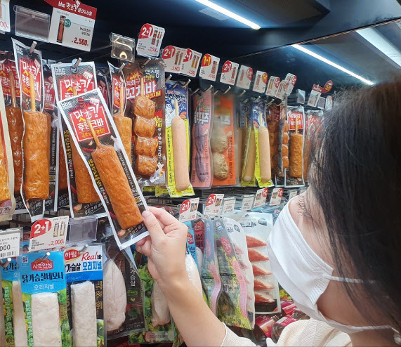 이마트24 매장에서 한 고객이 맛초킹 후랑크바를 살펴보고 있다.(사진=이마트24)