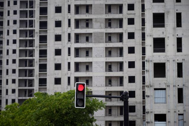 지난달 20일 중국 상하이의 한 아파트 공사 현장 인근의 신호등에 빨간불이 켜졌다. 상하이=로이터 연합뉴스