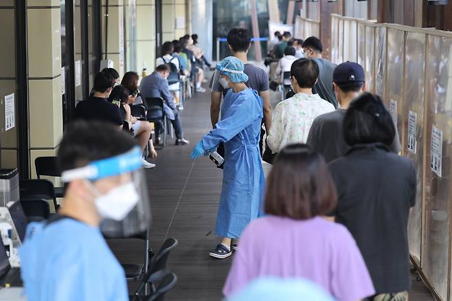 People line up to take a COVID-19 test at a testing clinic in Songpa, southern Seoul, on Friday. (Yonhap)