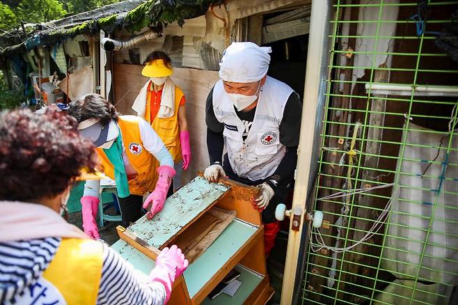 12일 서울 강남구 개포동 구룡마을에서 대한적십자사 봉사원들과 직원들이 잔해들을 정리하고 있다. [사진 = 대한적십자사]