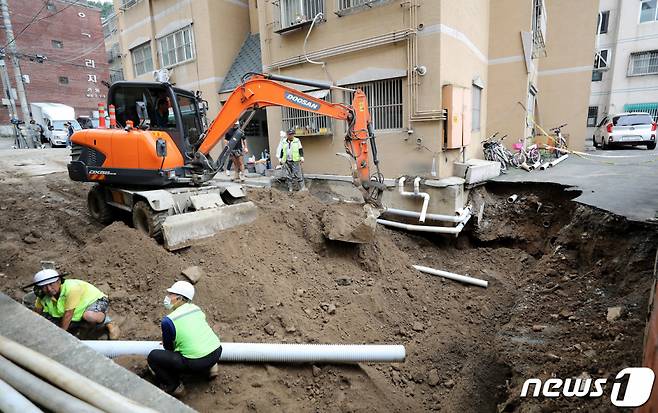 집중호우로 대형 싱크홀이 발생한 서울 양천구 신월동의 한 주택가에서 10일 오후 구청 관계자들이 복구 작업을 진행하고 있다. /사진=뉴스1