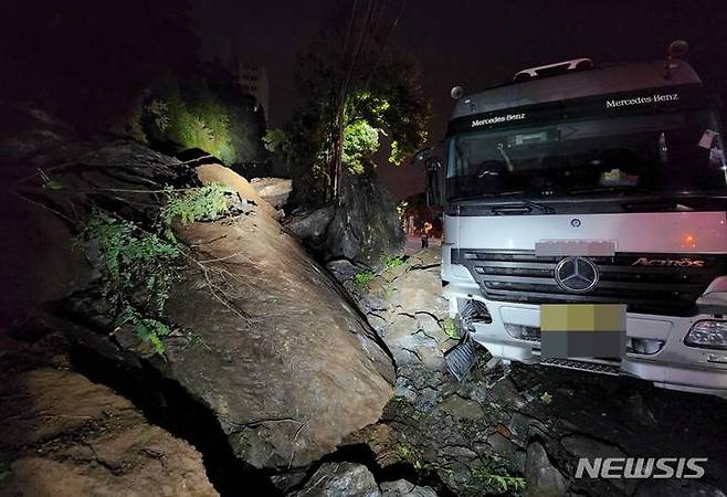 [군산=뉴시스]윤난슬 기자 = 12일 오전 0시 29분께 전북 군산시 해망동의 한 야산에서 여러 개의 바위가 도로 위로 굴러떨어졌다.2022.08.12.(사진=군산소방서 제공)