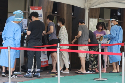 지난 12일 오전 서울 송파구보건소 선별진료소에서 시민들이 검사 순서를 기다리고 있다. [사진 출처 = 연합뉴스]