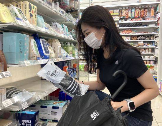 편의점 GS25에서 고객이 슬리퍼를 구매하고 있다.