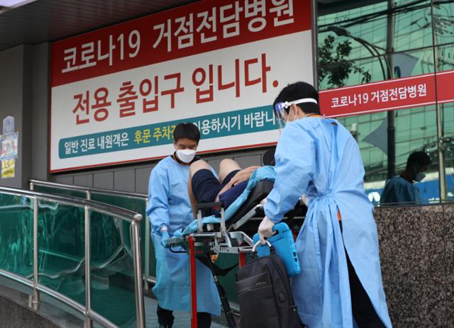 3일 오후 코로나19 거점전담병원인 서울 광진구 혜민병원에서 119 구급대원들이 환자를 이송하고 있다. 뉴스1