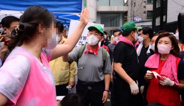 지난 11일 수해 복구 자원봉사를 위해 오전 서울 동작구 사당동을 찾은 국민의힘 주호영 비상대책위원장과 권성동 원내대표, 나경원 전 의원 등에게 한 시민이 길을 터 줄 것을 요구하고 있다. 국회사진기자단