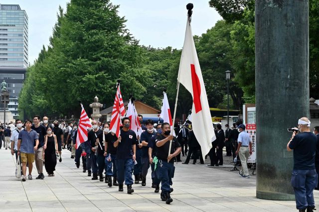 일본 극우단체 회원들이 15일 도쿄 야스쿠니신사에서 일장기와 욱일기를 들고 행진하고 있다. AFP연합뉴스