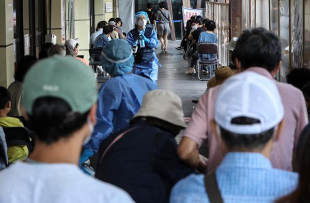 국내 코로나19 일일 확진자 수가 8만4,128명을 기록한 16일 오전 서울 송파구 선별진료소에서 시민들이 검사를 받기 위해 줄 서 있다. 뉴시스