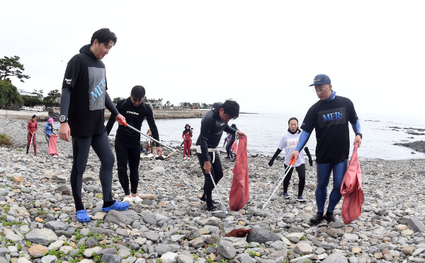 메르 프리다이빙 센터 교육생들이 서귀포 대평포구 인근 해변의 쓰레기를 줍는 해양정화활동을 하고 있다.