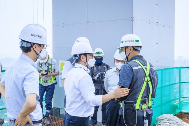 최익훈(앞줄 가운데) HDC현대산업개발 대표이사가 최근 ‘화정아이파크’ 현장을 찾아 박일곤(오른쪽 끝) 현장 관리감독자 등 엔지니어들을 격려하고 있다. HDC현대산업개발 제공