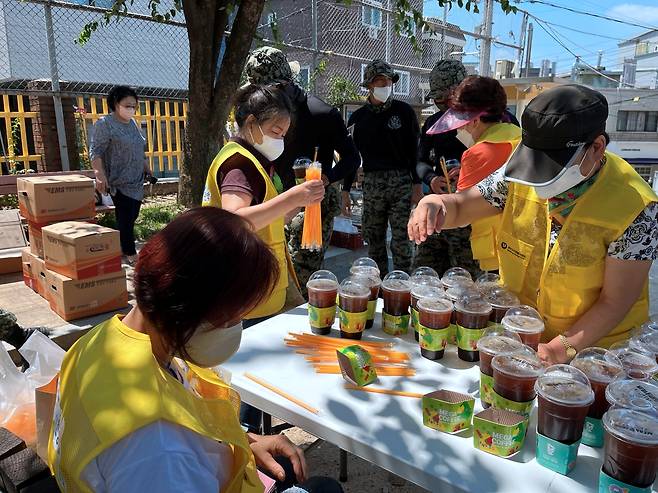 서울 관악구 수해복구 현장 자원봉사자들이 지난 12일 메가커피 본사에서 지원한 커피를 현장 봉사자들에게 나눠주고 있다. 관악구 제공.