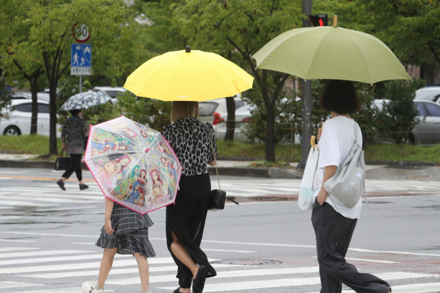 시민들이 우산을 쓰고 걷고 있다./연합뉴스