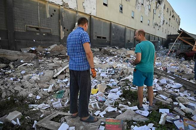 지난달 31일(현지시간) 우크라이나 제2의 도시 하르키우의 한 상가 잔해를 지역 주민들이 바라보고 있다. 이날 오전 러시아군이 미사일 공격을 하며 상가가 파괴됐다. 하르키우 | AFP연합뉴스