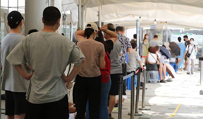 코로나19가 재확산하면서 17일 0시 기준 신규확진자가 18만803명을 기록하는 등 18주 만에 최고치를 기록한 이날 오후 서울 마포구보건소에 마련된 선별진료소에 검사를 받으려는 시민들이 줄을 서 있다. 신소영 기자 viator@hani.co.kr