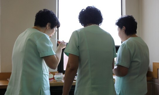 대학병원 간병인들이 병실 옆 배선실 창가에 서서 식사하고 있다. 한겨레 자료사진