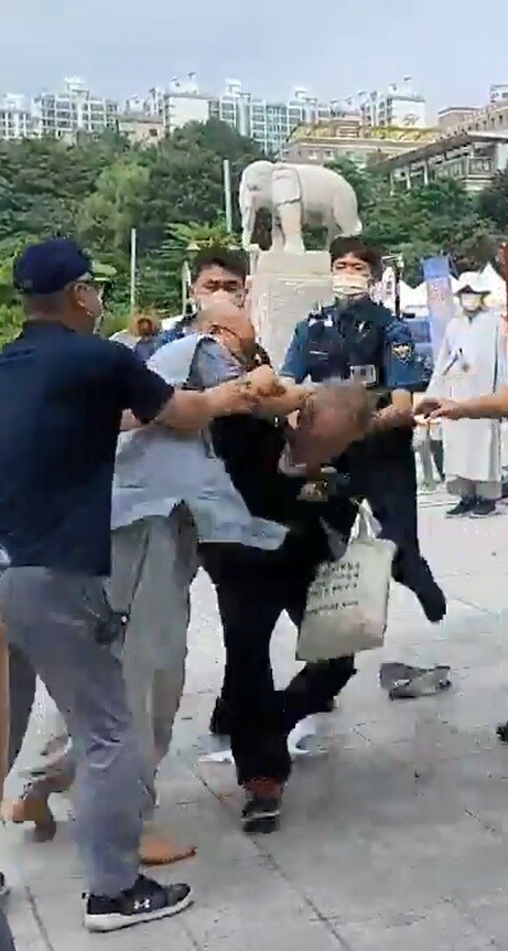 지난 14일 서울 강남 봉은사에서 한 승려가 박정규 조계종 민주노조 기획홍보부장을 폭행하고 있다. 조계종 민주노조 제공